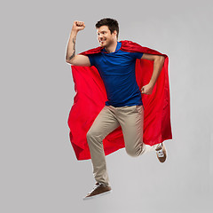 Image showing man in red superhero cape jumping in air