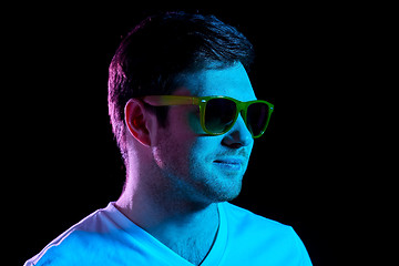 Image showing man in sunglasses over ultra violet neon lights