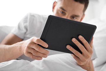 Image showing close up of man with tablet computer in bed