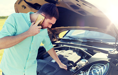 Image showing man with broken car calling on smartphone