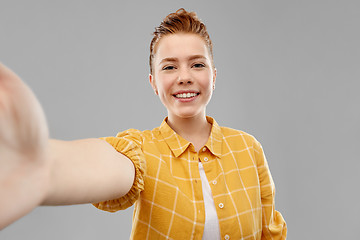 Image showing smiling red haired teenage girl taking selfie