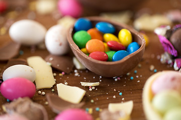 Image showing chocolate egg and candy drops on wooden table