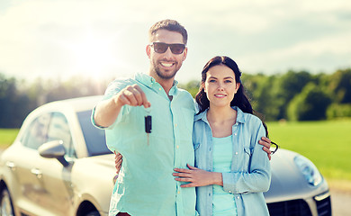 Image showing happy man and woman with car key hugging