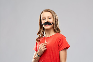 Image showing smiling teenage girl with mustaches party prop