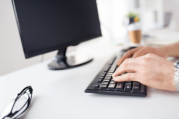 Image showing close up of male hands typing on computer keyboard