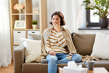 Image showing sick woman in blanket coughing at home