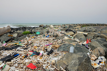 Image showing Spilled garbage on the beach near the big city. Empty used dirty plastic bottles and other garbage. Environmental pollution. Ecological problem.