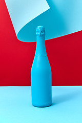 Image showing Painted blue mock-up bottle of wine on a duotone curly background.