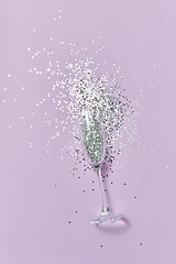 Image showing The glass of champagne with bright silver confetti with soft shadows.