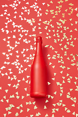 Image showing Holiday composition from painted red bottle on a shiny background.
