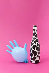 Image showing Balloon rubber glove with painted white bottle with black spots.