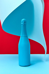 Image showing Mock up blue painted wine bottle with folded paper.