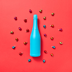 Image showing Blue painted mock up bottle on a background covered Christmas balls.