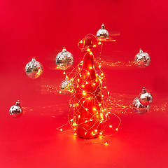 Image showing Flying Cristmas balls around painted wine bottle with string of lights.