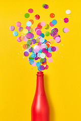 Image showing Colorful confetti as a bubble foam from painted red wine bottle.