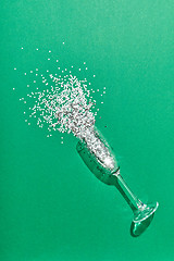 Image showing Colorful Christmas tinsel in a glass as a champagne drink bubbles.