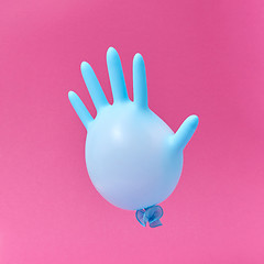 Image showing Blue latex glove balloon on a hot pink background.