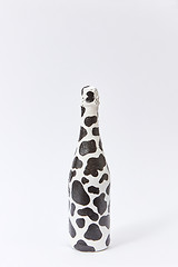 Image showing Creative white wine bottle painted with black spots.