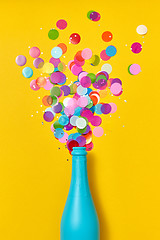 Image showing Multicolored confetti as a bubble foam above open champagne bottle.