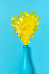 Image showing Blue painted champagne bottle with yellow confetti bubbles.