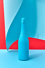 Image showing Decorative painted blue wine bottle mock up on a duotone wavy background.