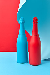 Image showing Wine bottles mock-up painted red and blue on a duotone curly background.