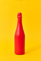 Image showing Red painted spray mockup bottle on an yellow background.