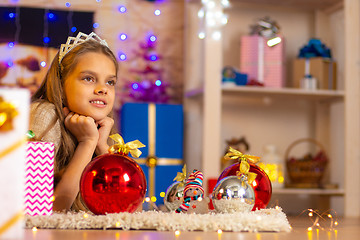 Image showing Beautiful ten-year-old girl lies on a rug in the New Year\'s interior