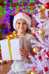 Image showing Girl sitting by the Christmas tree with big gifts in her hands