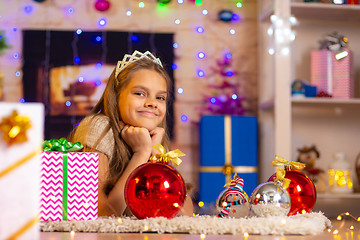 Image showing Beautiful ten-year-old girl lies on a rug in the New Year\'s interior and looks at the frame cheerfully