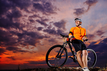 Image showing Man in helmet and glasses stay on the bicycle