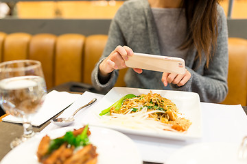 Image showing Woman taking photo on dishes in restaurant