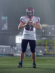 Image showing portrait of confident American football player standing on the f