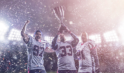 Image showing american football team with trophy celebrating victory in the cu