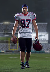 Image showing portrait of young confident American football player walking thr