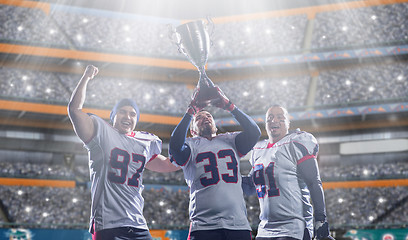 Image showing american football team with trophy celebrating victory in the cu