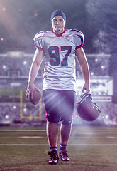 Image showing portrait of young confident American football player walking thr