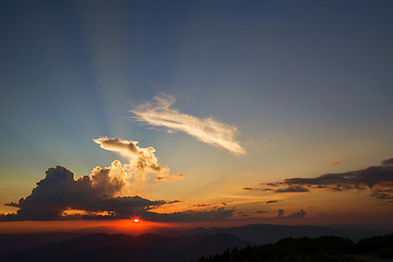 Image showing Sunset orange sun, rays over the mountains