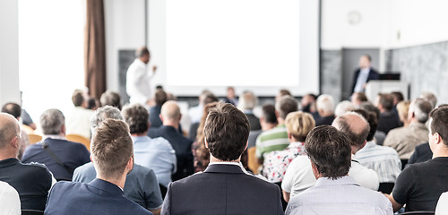 Image showing I have a question. Group of business people sitting in conference hall. Businessman raising his arm. Conference and Presentation. Business and Entrepreneurship