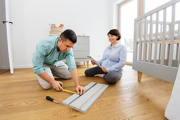 Image showing family couple assembling baby bed at home