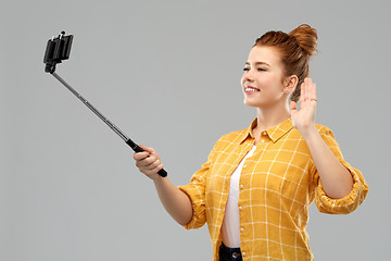 Image showing happy teenage girl taking picture by selfie stick