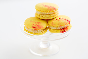 Image showing lemon yellow macarons on glass confectionery stand