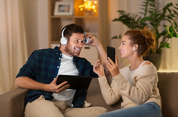 Image showing couple with gadgets listening to music at home