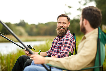 Image showing happy friends with fishing rods on lake