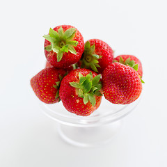 Image showing strawberries on glass stand over white background