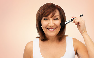 Image showing smiling senior woman with make up blush brush
