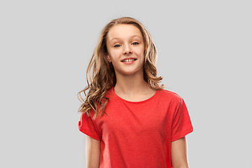 Image showing smiling teenage girl in red t-shirt over grey