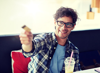 Image showing happy man paying with credit card at cafe