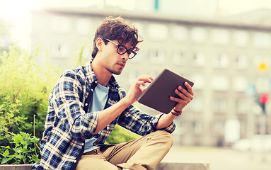 Image showing man with tablet pc sitting on city street bench