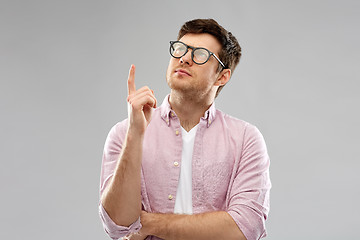 Image showing young man in glasses pointing finger up